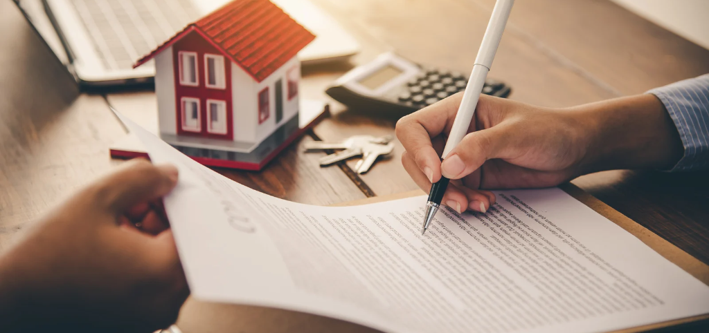 Hand holding a pen over a mortgage agreement from Future Balance